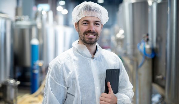 ritratto-di-un-tecnologo-sorridente-in-un-impianto-industriale_342744-12211